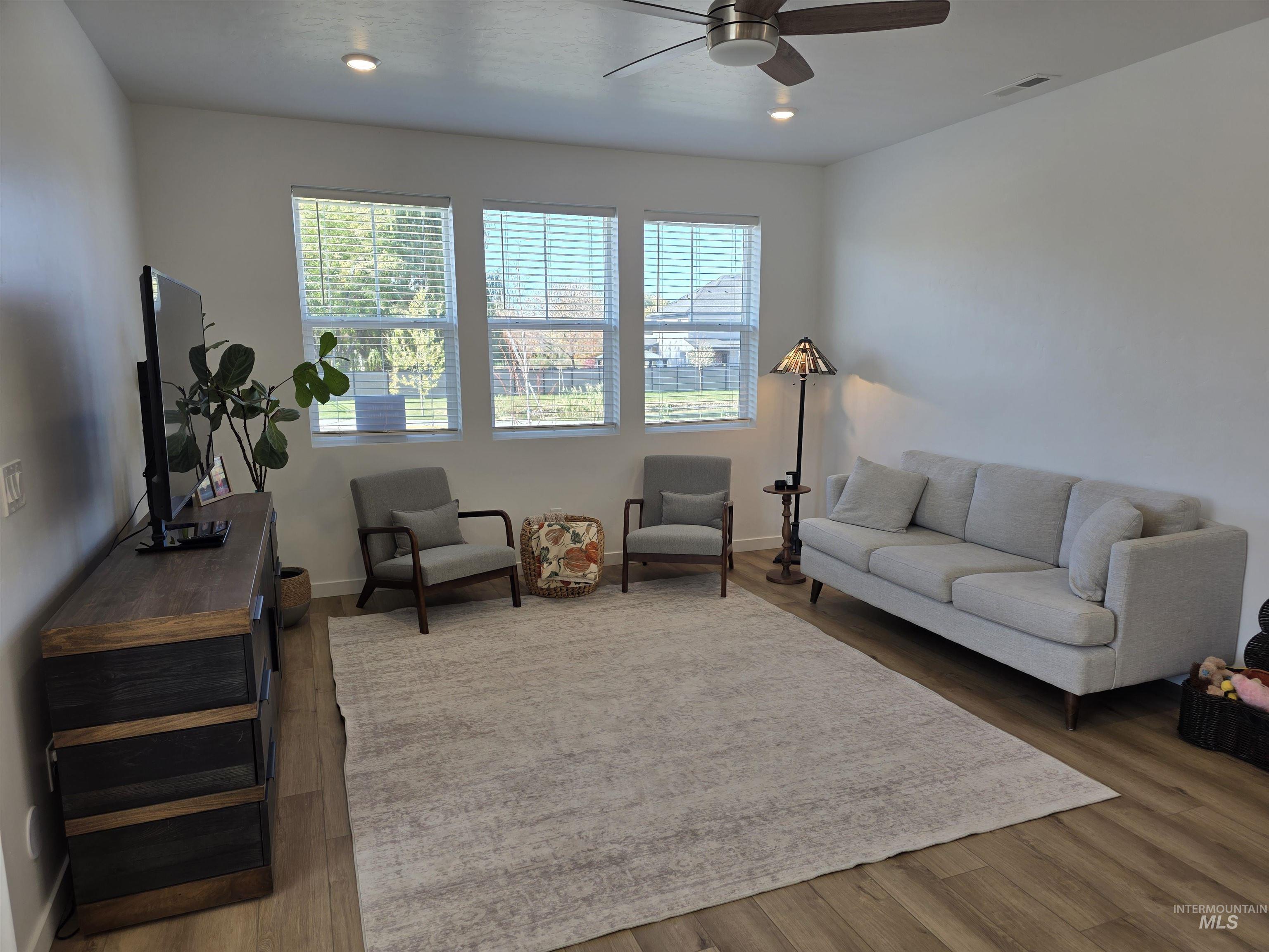 168 North Stratus Way Eagle, ID 83616 - Photo 12 of 35 Living area featuring wood finished floors, recessed lighting, and ceiling fan