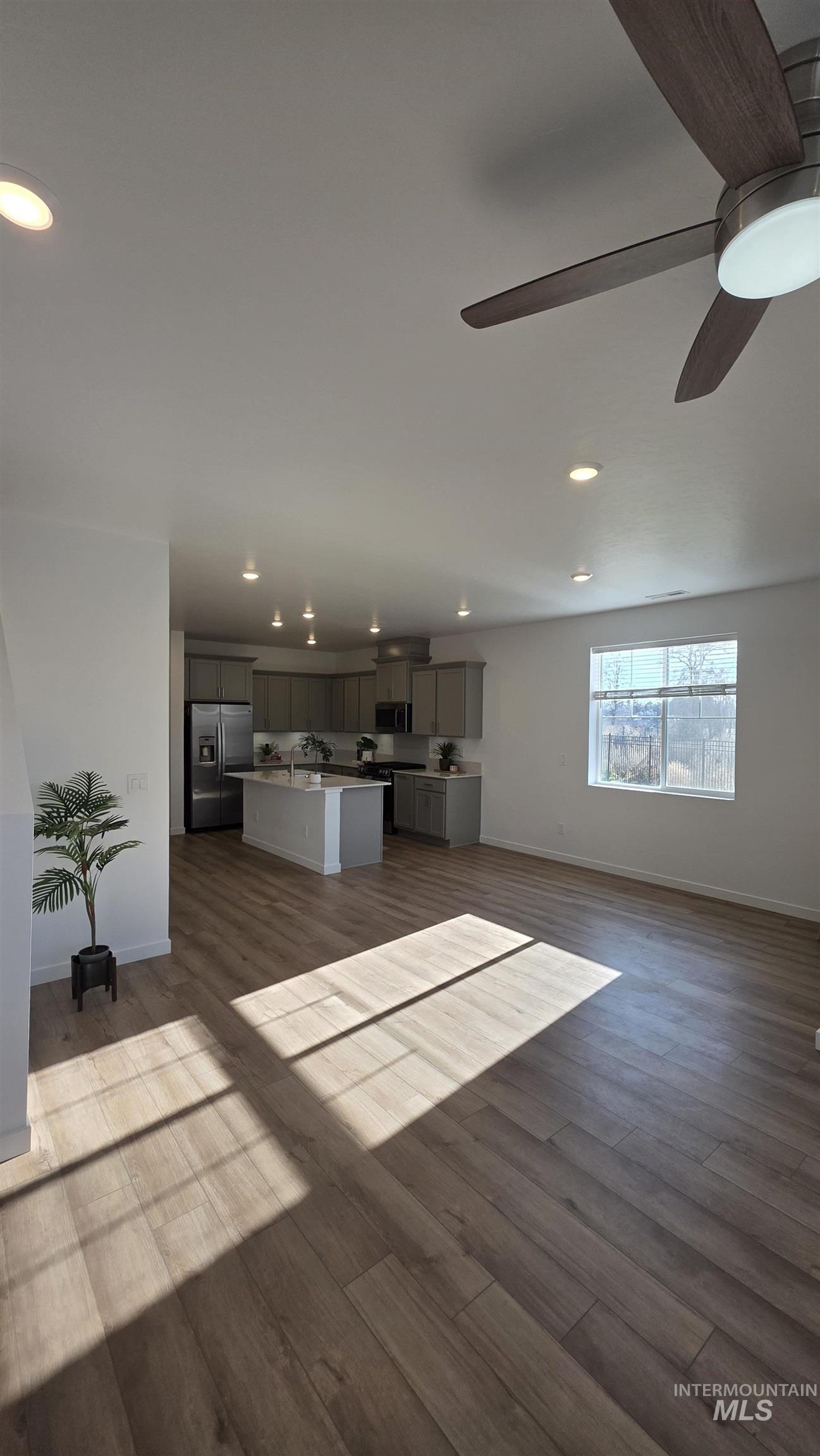 168 North Stratus Way Eagle, ID 83616 - Photo 5 of 35 Unfurnished living room with dark wood finished floors, recessed lighting, and a ceiling fan