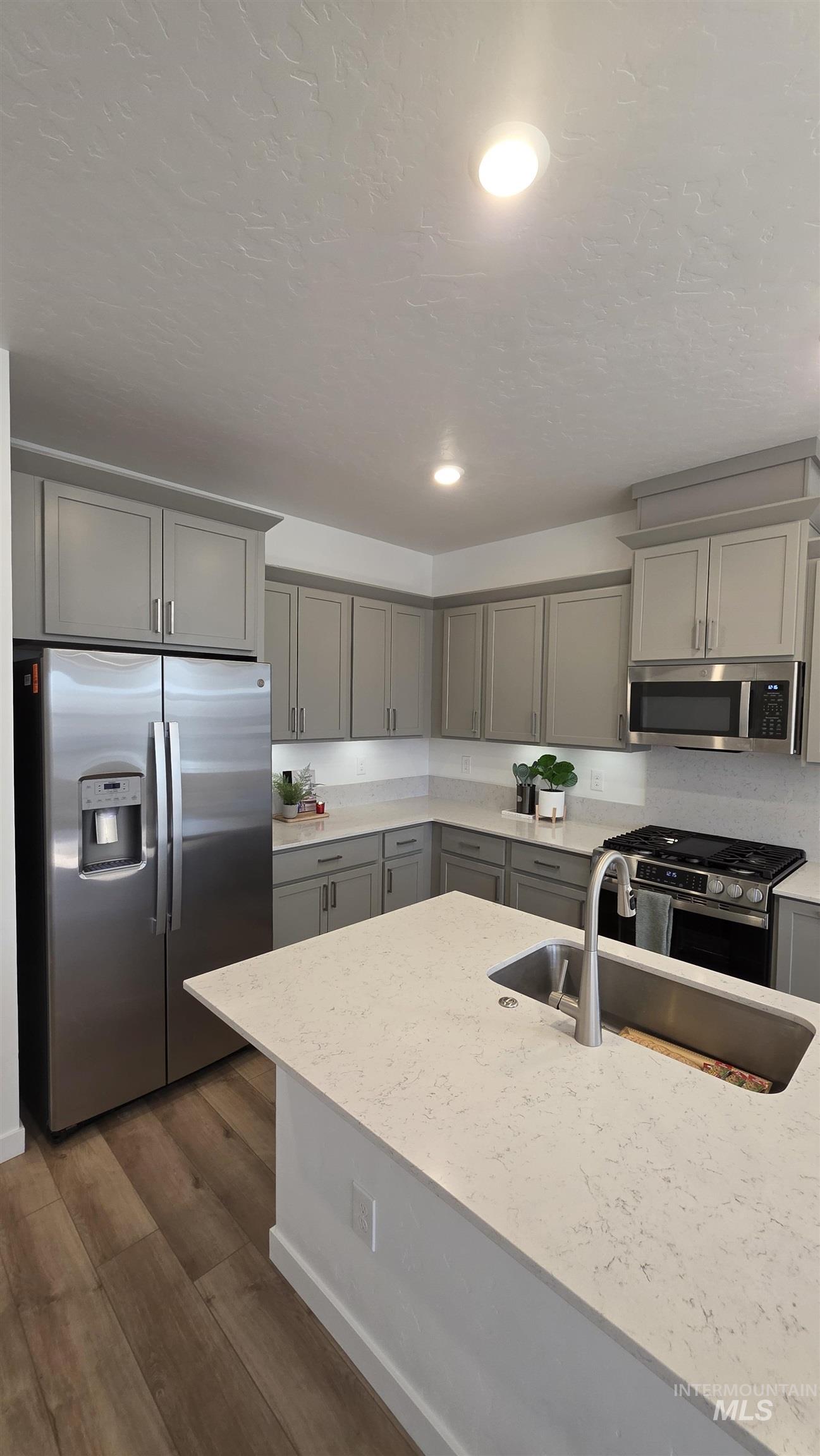 168 North Stratus Way Eagle, ID 83616 - Photo 8 of 35 Kitchen featuring stainless steel appliances, gray cabinets, light stone countertops, dark wood-type flooring, and recessed lighting