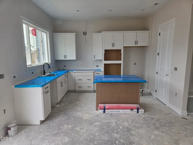 a kitchen with granite countertop a sink stove and cabinets