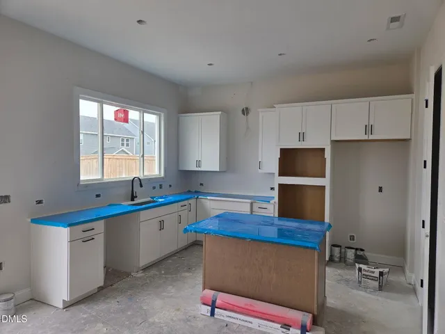 a kitchen with granite countertop a sink appliances and cabinets