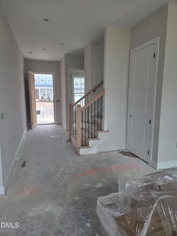 a view of an empty room with window and stairs