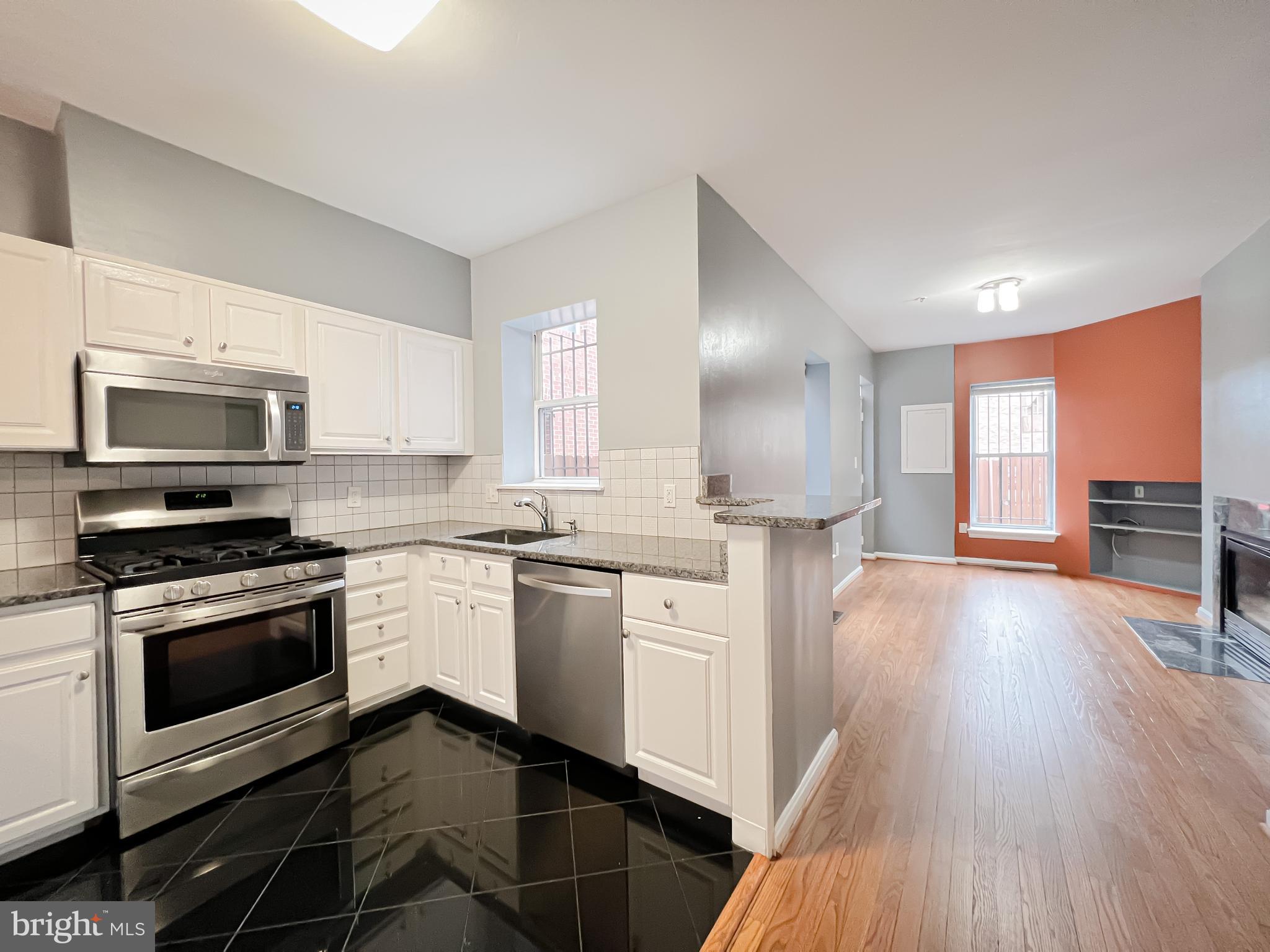 617 U Street Northwest Washington, DC 20001 - Photo 7 of 27 a kitchen with stainless steel appliances granite countertop a stove a sink dishwasher a microwave oven and a refrigerator with wooden floor
