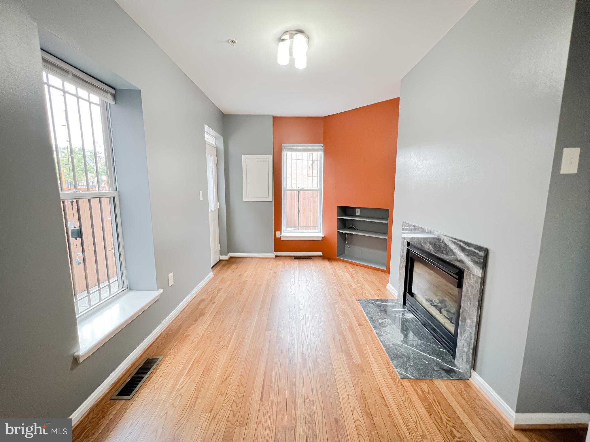 617 U Street Northwest Washington, DC 20001 - Photo 8 of 27 a view of an empty room with wooden floor fireplace and a window