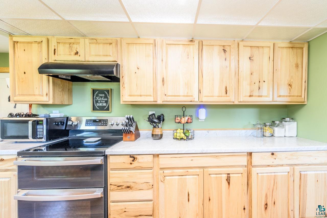 2581 O'Rourke Road Hibbing, MN 55746 - Photo 8 of 61 Natural wood cabinetry with light countertops and a built-in stainless steel range