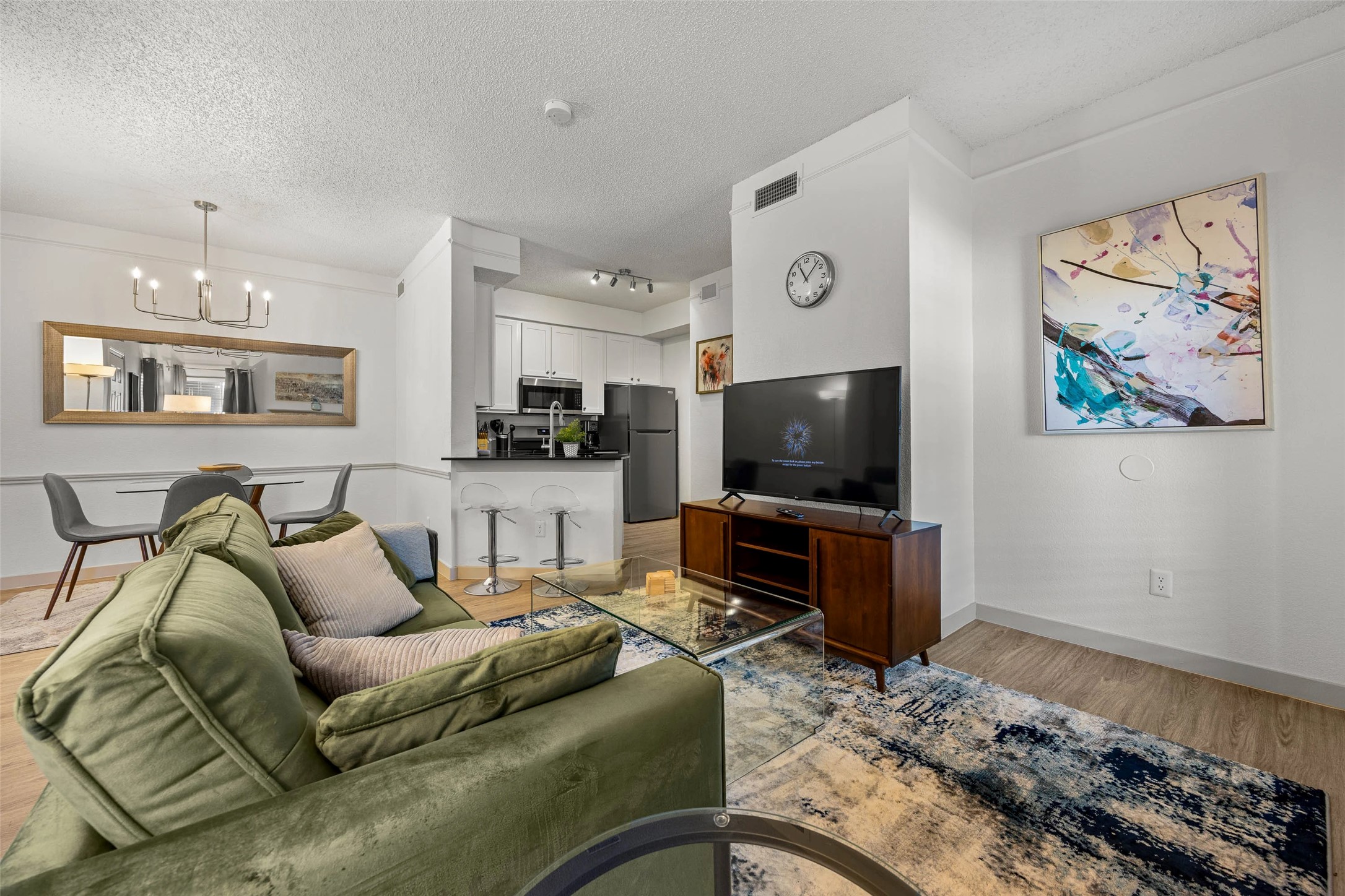 11908 Anderson Mill Road, Unit 822 Austin, TX 78726 - Photo 13 of 23 Living area featuring a textured ceiling, a chandelier, ornamental molding, track lighting, and light wood-style flooring
