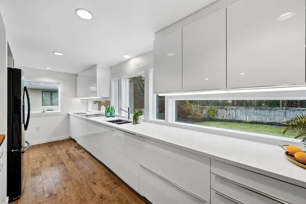 a large white kitchen with a large window