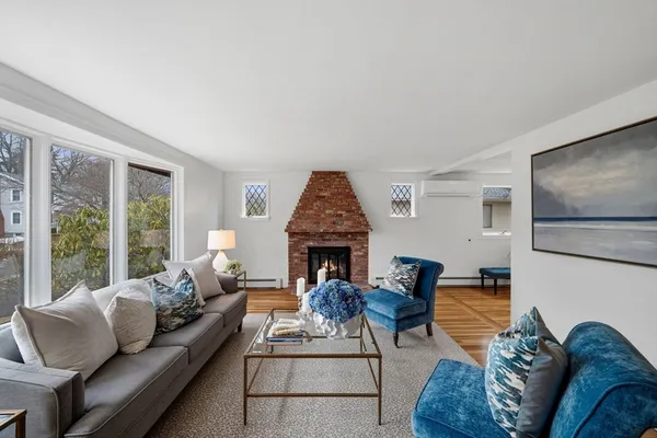 a living room with furniture fireplace and large window