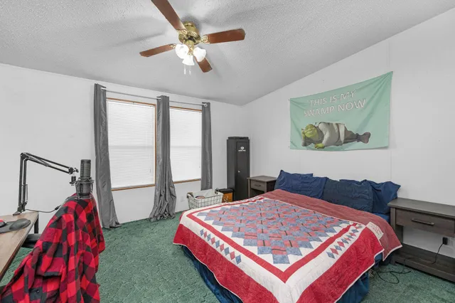 a bedroom with a bed a chandelier and a dresser