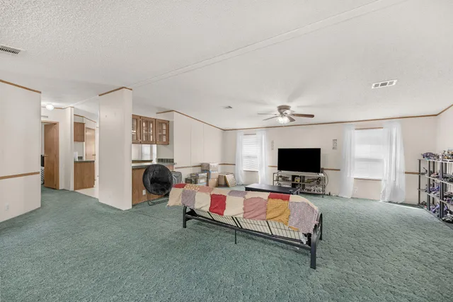 a kitchen with granite countertop a refrigerator a sink and white cabinets