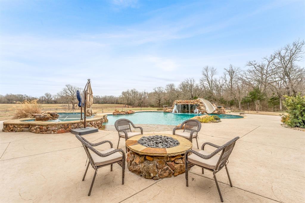 239 32507th Road Paris, TX 75460 - Photo 28 of 40 View of patio featuring a fire pit, an outdoor pool, and an in-ground hot tub