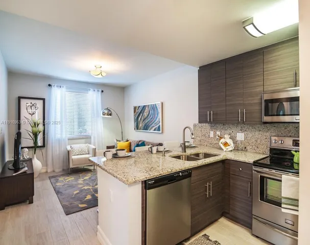 a kitchen with stainless steel appliances granite countertop a sink stove and refrigerator