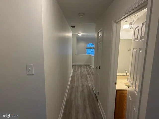 a view of hallway with wooden floor