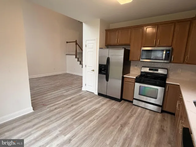a kitchen with wooden floors and stainless steel appliances