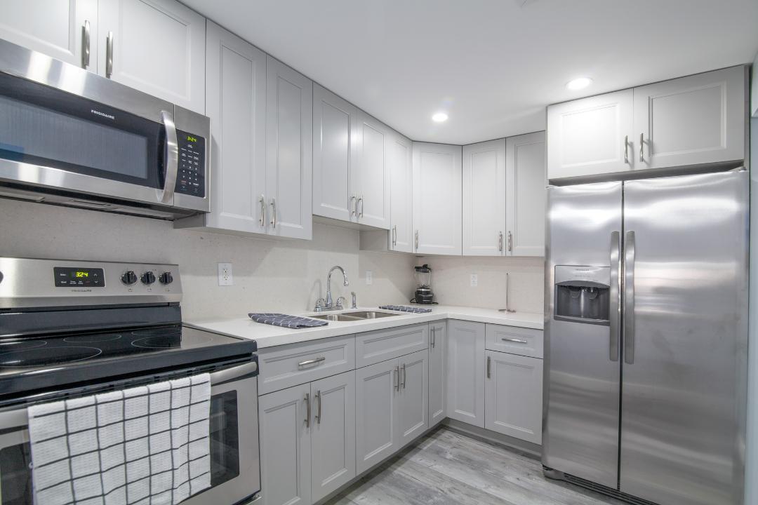 320 South Surf Road, Unit 205 Hollywood, FL 33019 - Photo 13 of 18 a kitchen with stainless steel appliances granite countertop a refrigerator sink and cabinets