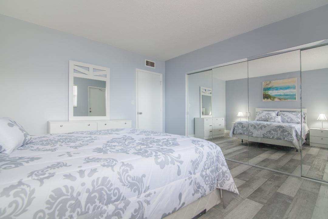 320 South Surf Road, Unit 205 Hollywood, FL 33019 - Photo 15 of 18 a bedroom with a bed and a large mirror