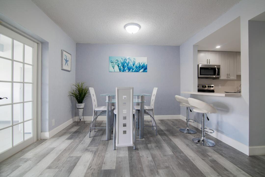 320 South Surf Road, Unit 205 Hollywood, FL 33019 - Photo 5 of 18 a view of a dining room with furniture a rug and wooden floor