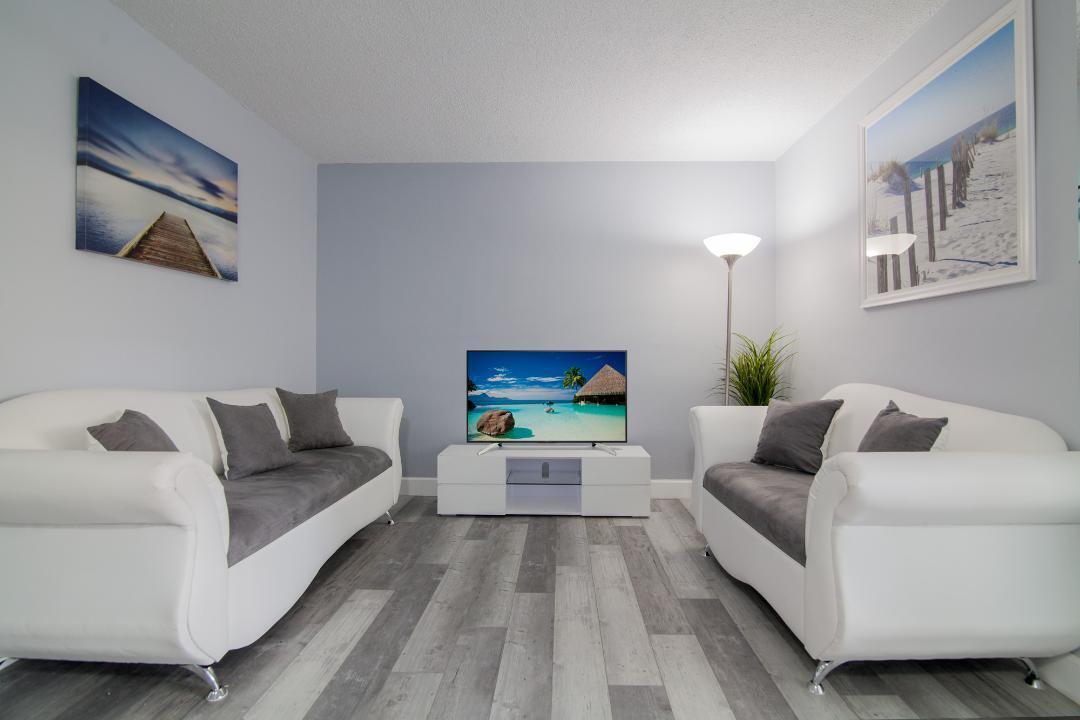 320 South Surf Road, Unit 205 Hollywood, FL 33019 - Photo 6 of 18 a living room with furniture and a flat screen tv