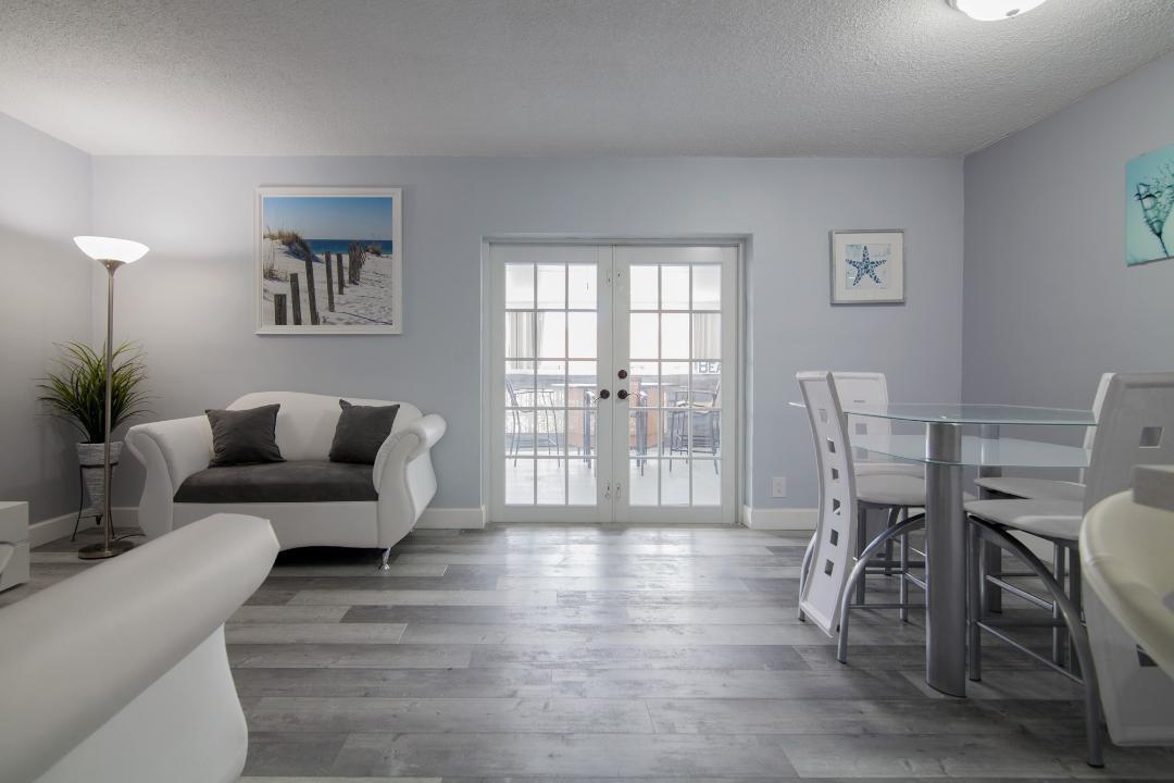 320 South Surf Road, Unit 205 Hollywood, FL 33019 - Photo 7 of 18 a living room with furniture and a table with wooden floor