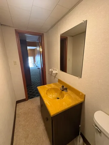 a bathroom with a toilet sink and mirror