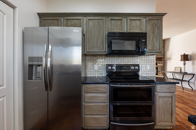 6 300th Road North, Unit I6 Kanab, UT 84741 - Photo 14 of 37 Kitchen with stainless steel refrigerator with ice dispenser, double oven range, black microwave, dark wood-style flooring, and dark stone counters