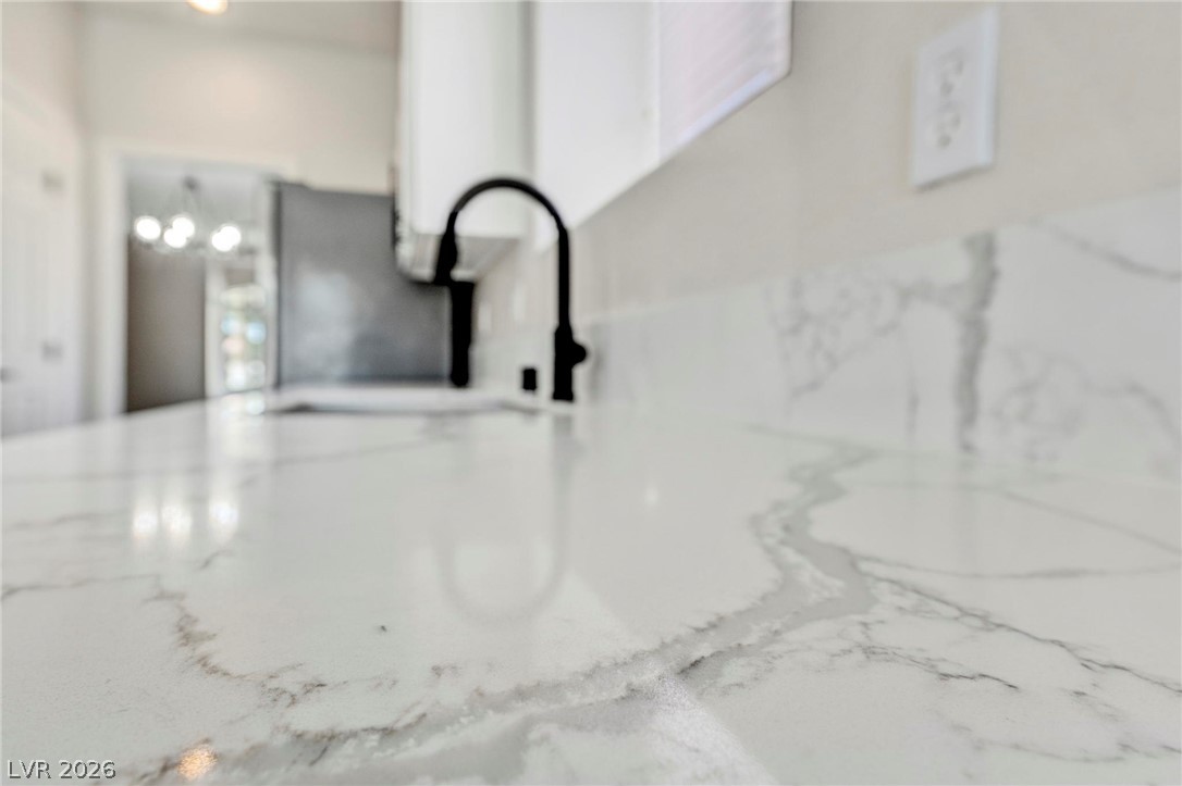 740 Aldo Rae Court, Unit NONE Henderson, NV 89052 - Photo 15 of 35 Marble-look countertops with elegant veining extend, showcasing a contemporary kitchen aesthetic.