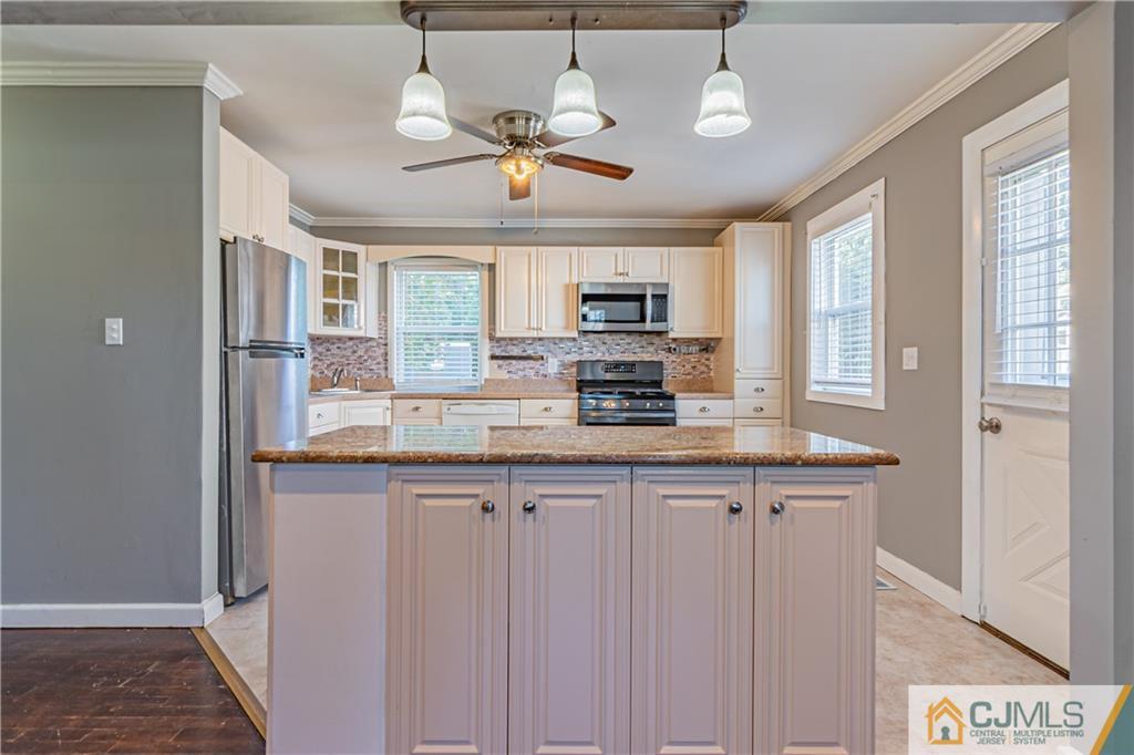 12 Jones Place Edison, NJ 08817 - Photo 14 of 28 a kitchen with kitchen island granite countertop a sink cabinets and window