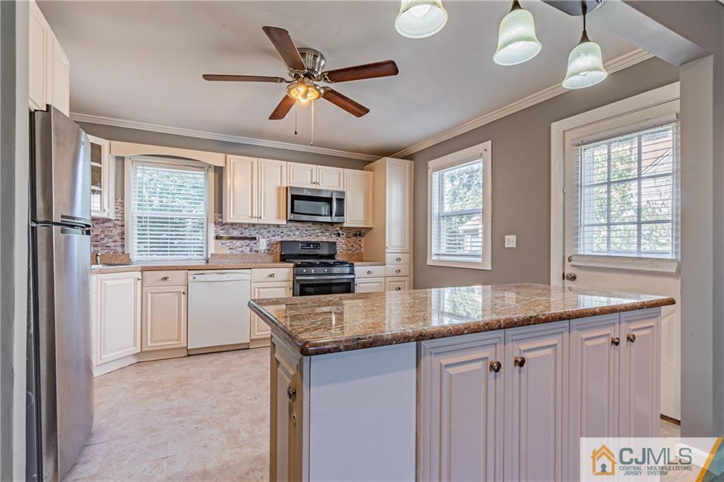 12 Jones Place Edison, NJ 08817 - Photo 15 of 28 a kitchen with granite countertop a center island a window appliances and cabinets