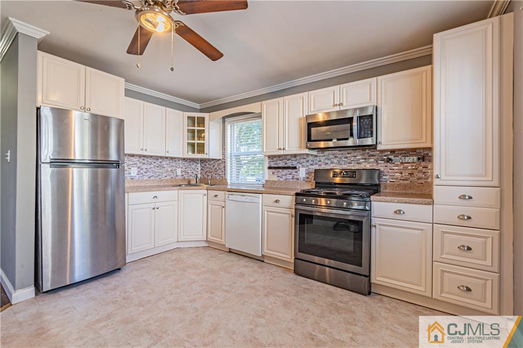 12 Jones Place Edison, NJ 08817 - Photo 16 of 28 a kitchen with cabinets stainless steel appliances and a window