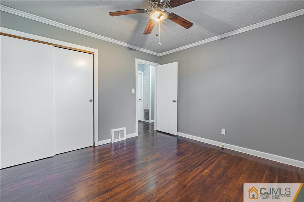 12 Jones Place Edison, NJ 08817 - Photo 20 of 28 an empty room with wooden floor chandelier fan and closet area