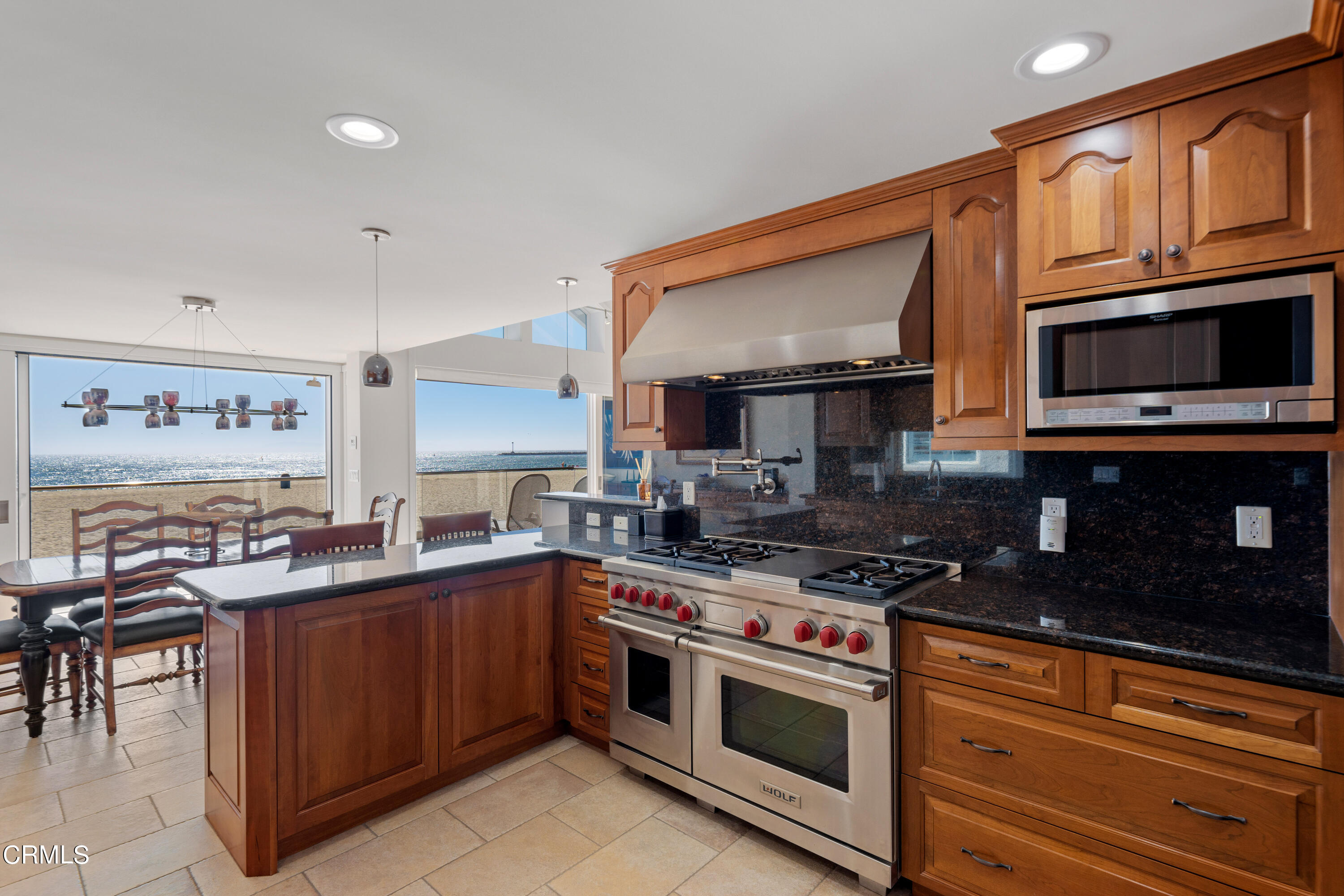 2013 Ocean Drive Oxnard, CA 93035 - Photo 25 of 60 a kitchen with stainless steel appliances granite countertop a stove top oven a sink dishwasher and cabinets with wooden floor