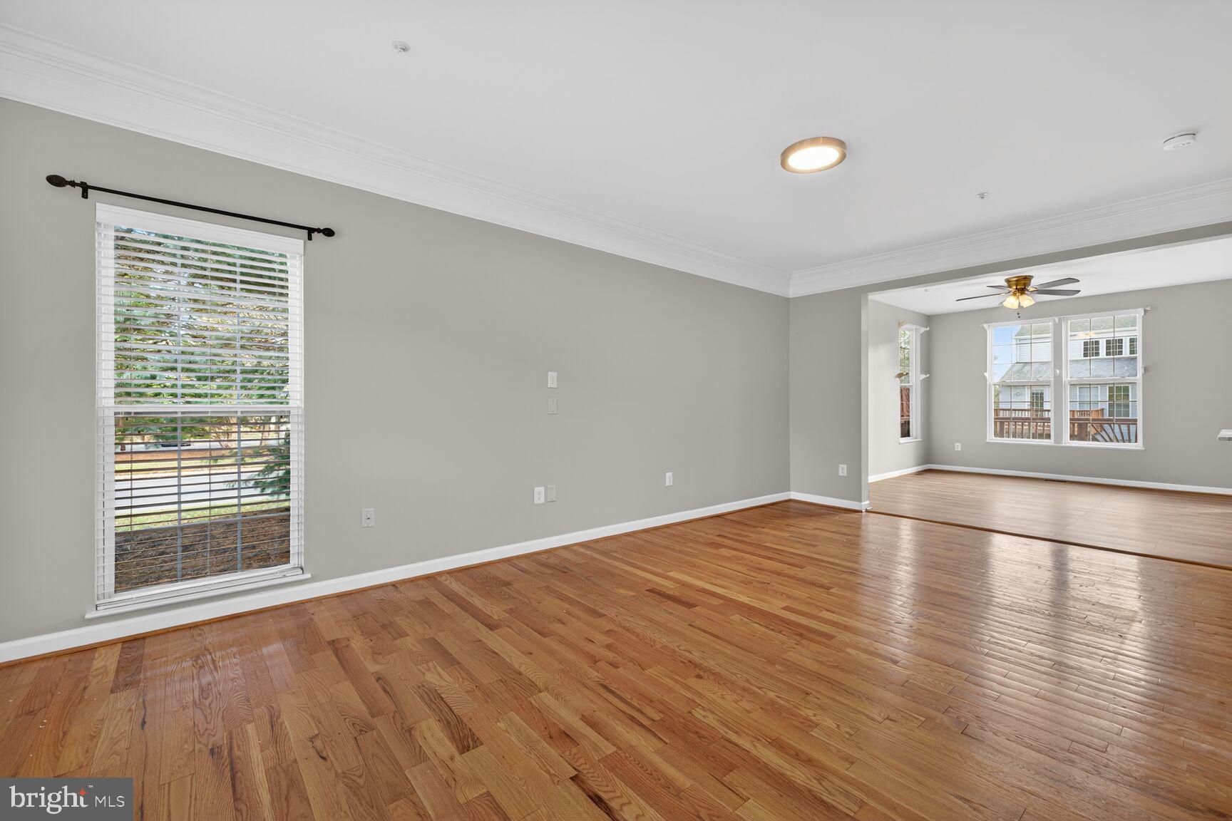 6715 Manorly Court Frederick, MD 21703 - Photo 5 of 15 a view of an empty room with window and wooden floor