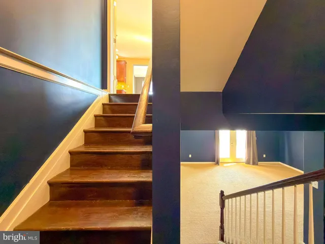 a view of a livingroom with wooden floor and staircase