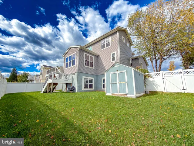 a view of a house with a big yard and large trees