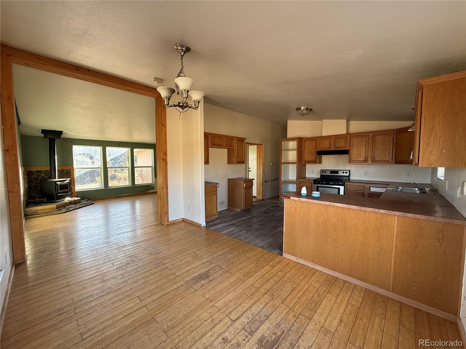 577 Fdr 101 Road Antonito, CO 81120 - Photo 13 of 40 a large kitchen with cabinets wooden floor and a refrigerator