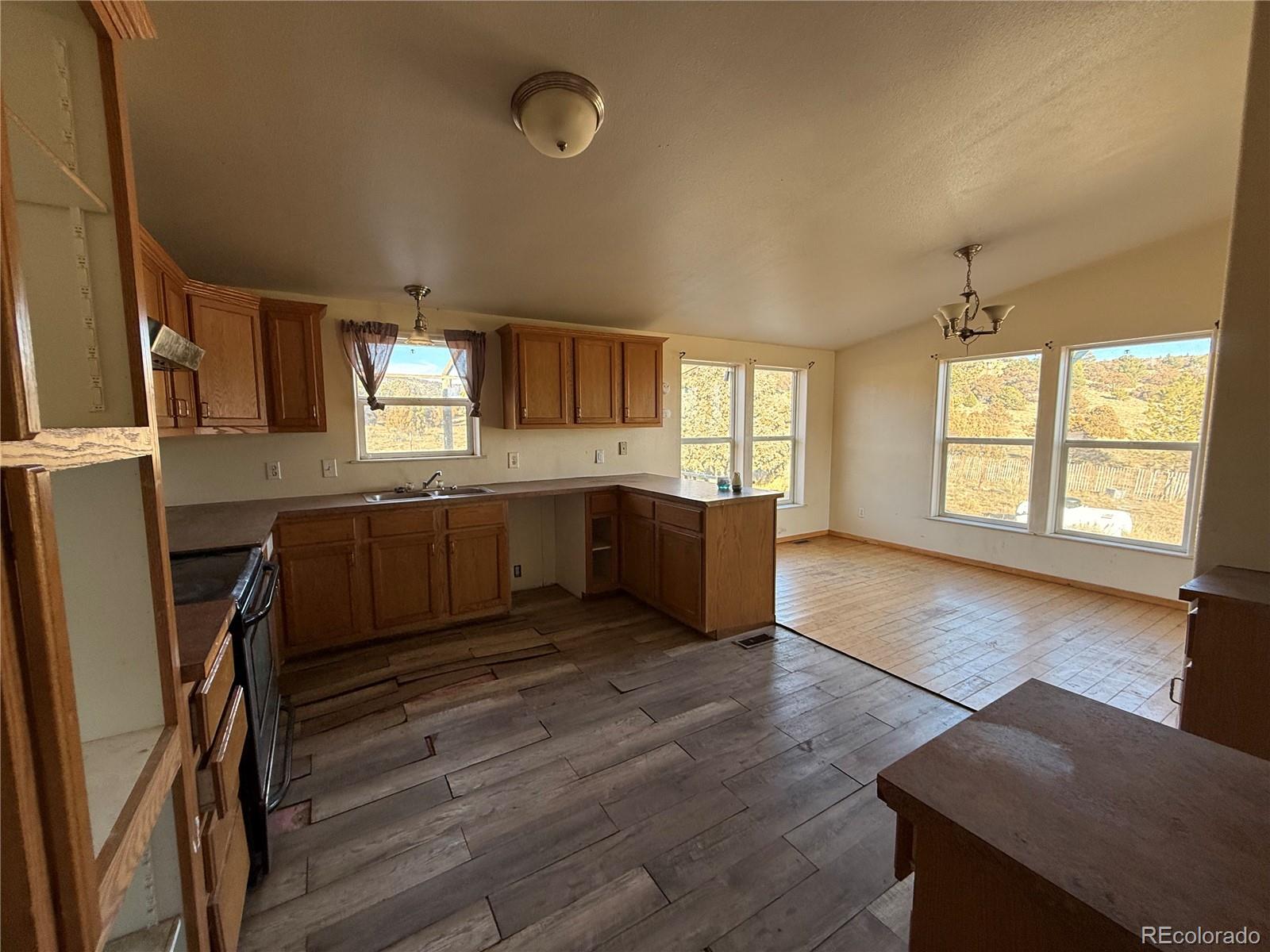 577 Fdr 101 Road Antonito, CO 81120 - Photo 16 of 40 a large kitchen with cabinets wooden floor and stainless steel appliances