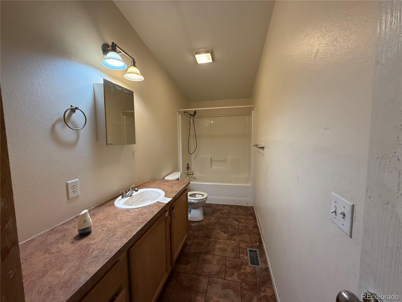 577 Fdr 101 Road Antonito, CO 81120 - Photo 20 of 40 a bathroom with a granite countertop sink a toilet and a shower