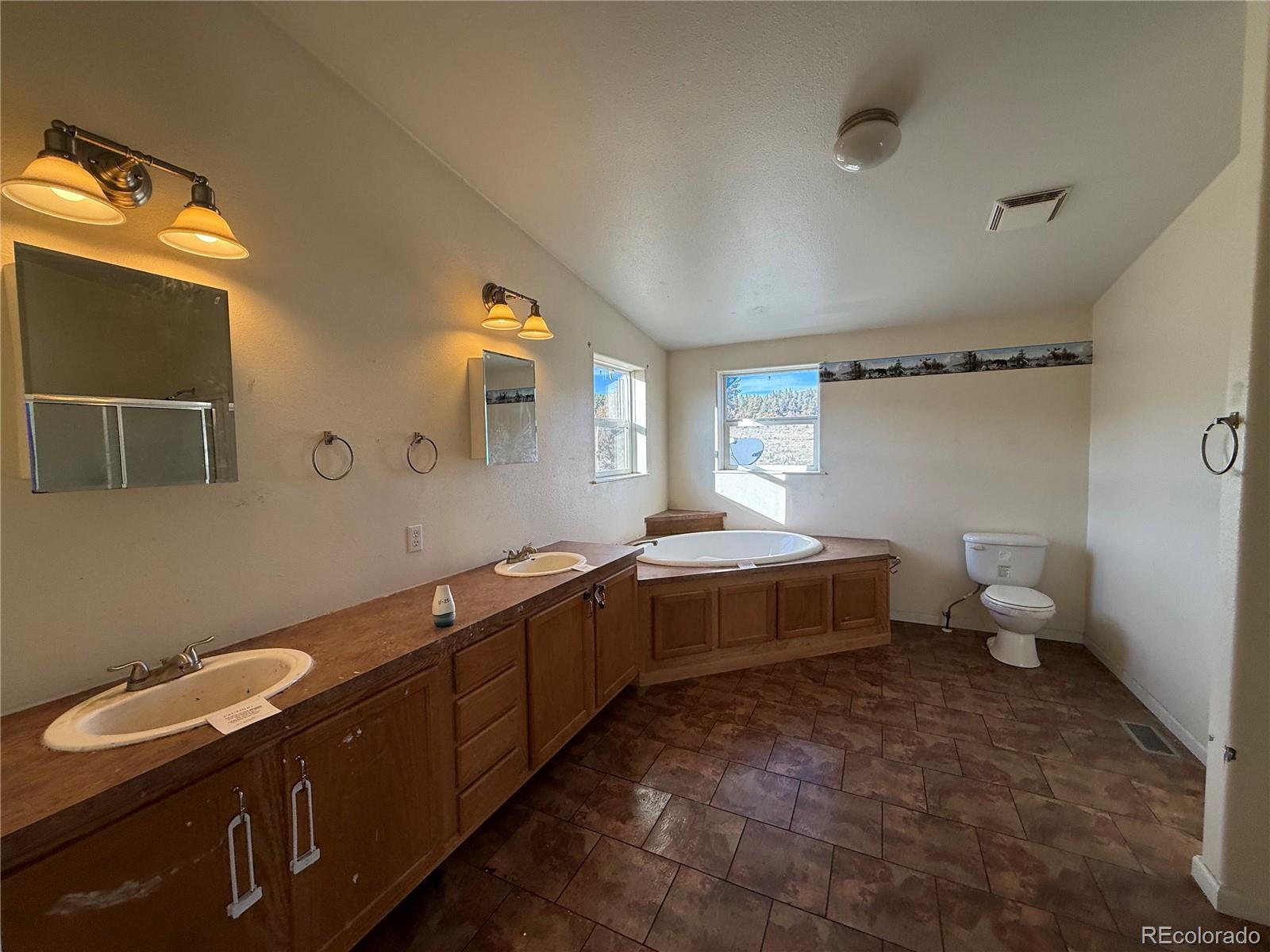 577 Fdr 101 Road Antonito, CO 81120 - Photo 23 of 40 a spacious bathroom with a double vanity sink a mirror and a toilet