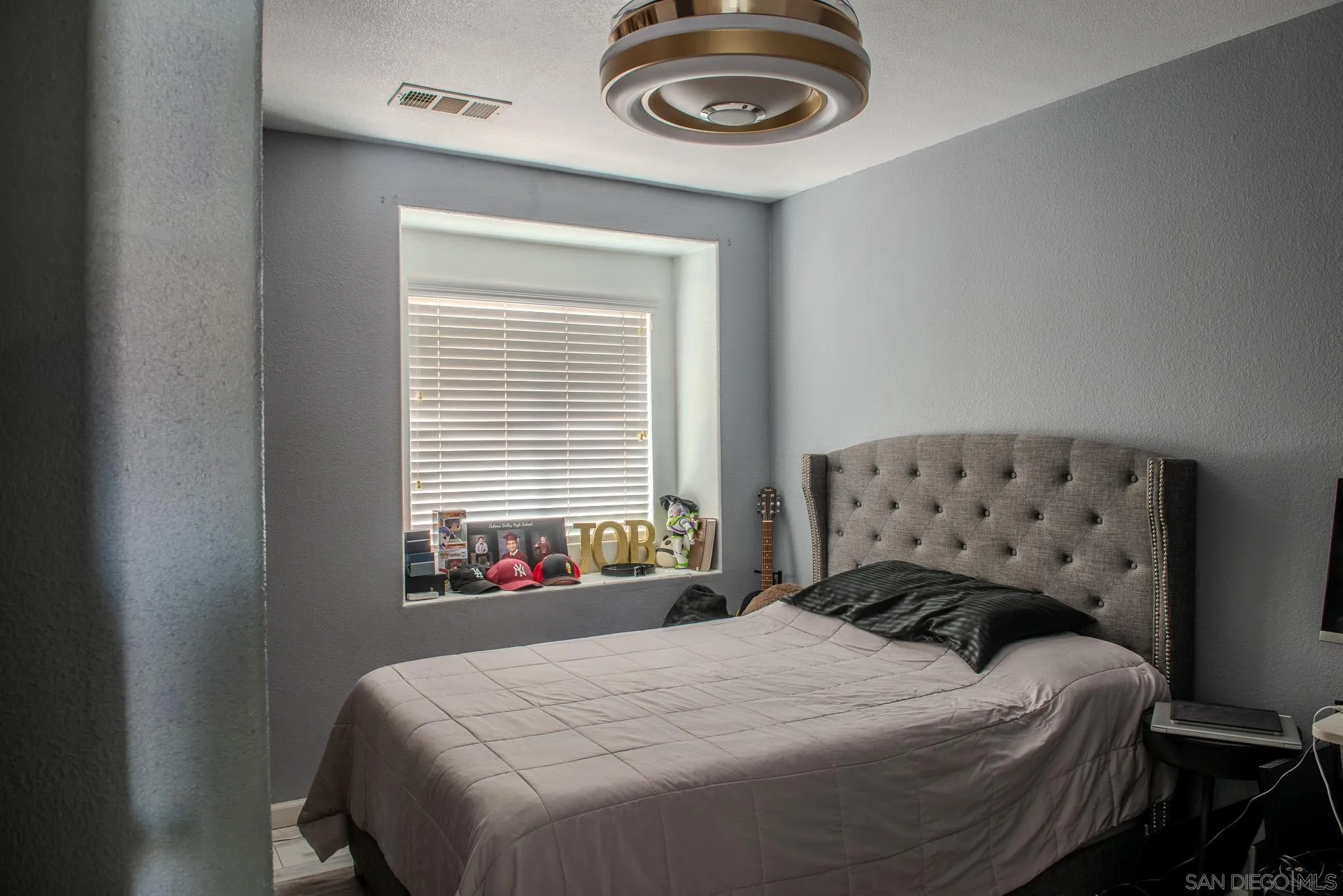 33567 Magnetite Street Menifee, CA 92584 - Photo 30 of 49 a bedroom with a bed and a chandelier
