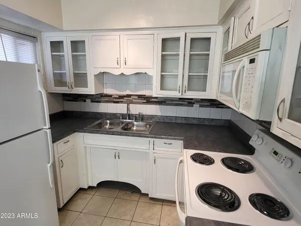 a kitchen with a sink a stove and cabinets