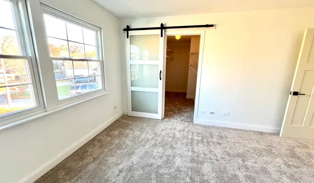 an empty room with windows and closet