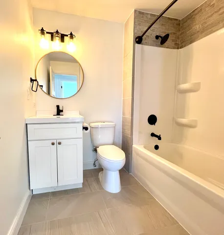 a bathroom with a toilet sink vanity tub and shower