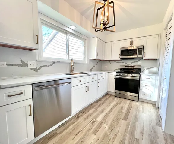 a kitchen with granite countertop a sink stainless steel appliances and cabinets