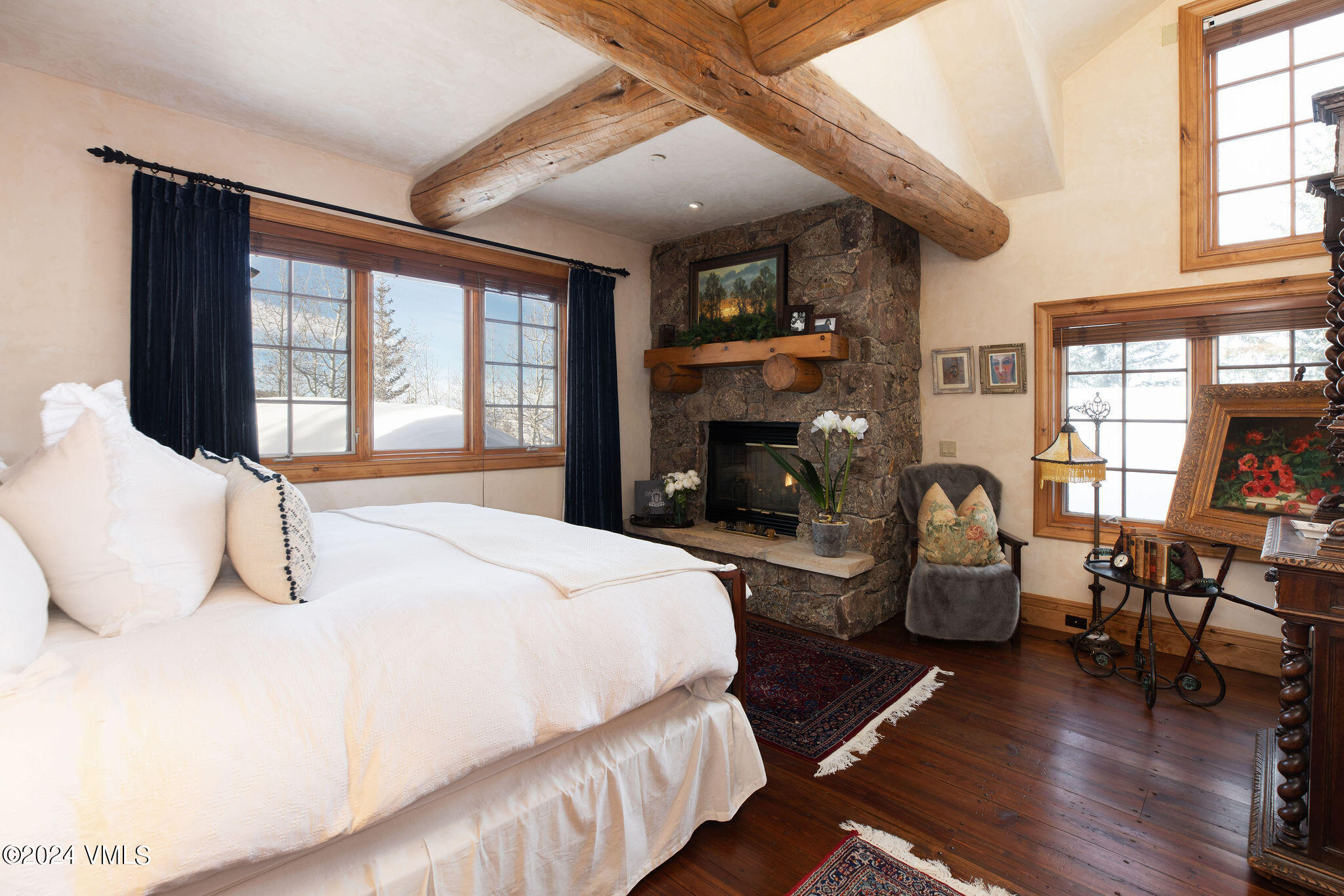 2187 Daybreak Ridge Road Avon, CO 81620 - Photo 24 of 40 a bedroom with a bed a fireplace and windows