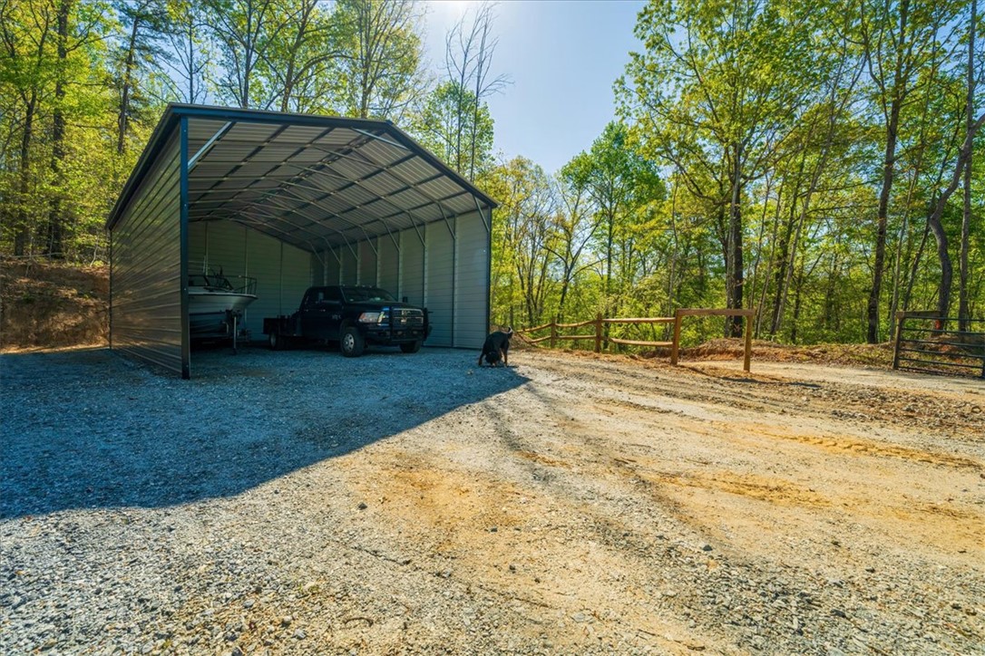 280 Dan Ross Road Six Mile, SC 29682 - Photo 22 of 24 This expansive lot features a durable carport, providing ample sheltered parking amidst a natural setting.