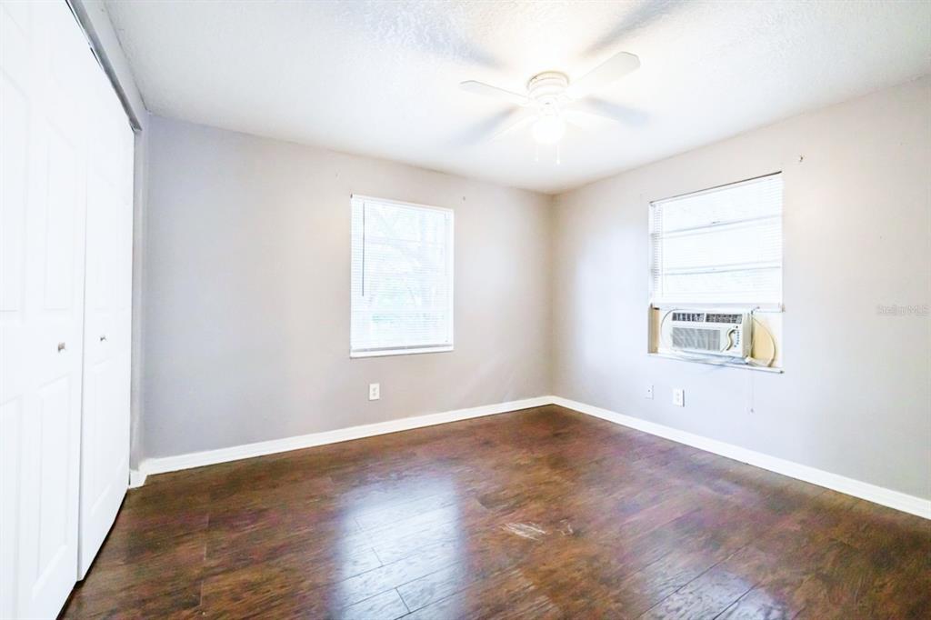 2507 West Virginia Avenue, Unit D Tampa, FL 33607 - Photo 5 of 12 an empty room with wooden floor and windows