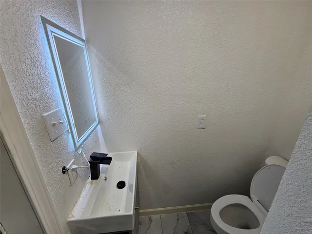 a kitchen with granite countertop a sink a stove and cabinets