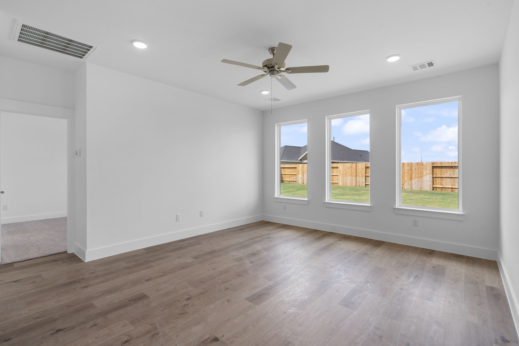 225 Sandhill Grv Trail Hempstead, TX 77445 - Photo 3 of 27 a view of an empty room with wooden floor and a window