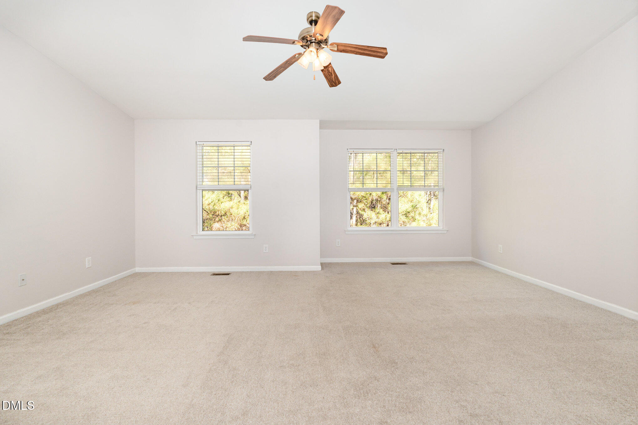 311 Gilman Lane, Unit 107 Raleigh, NC 27610 - Photo 13 of 21 an empty room with windows and chandelier fan