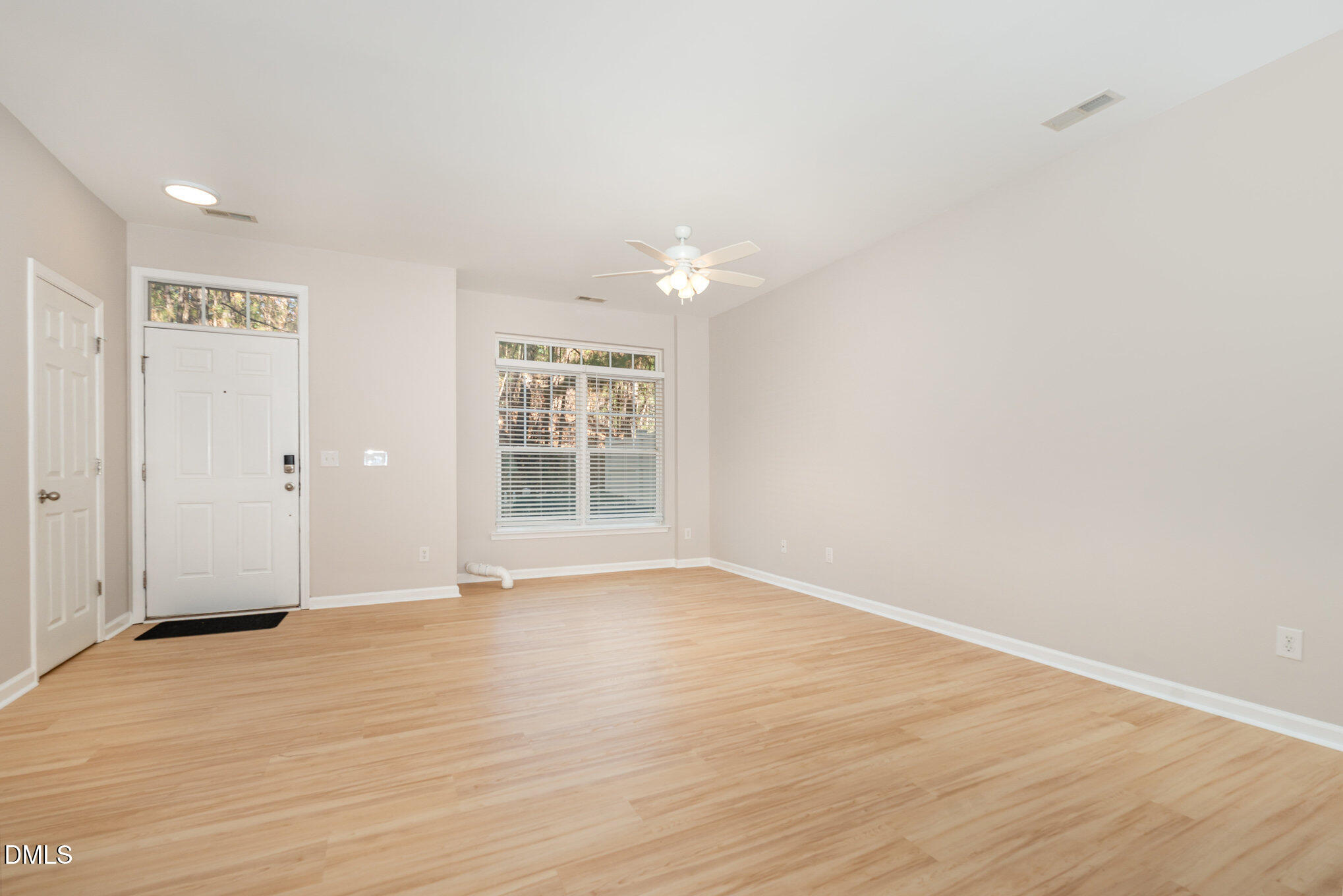 311 Gilman Lane, Unit 107 Raleigh, NC 27610 - Photo 3 of 21 a view of an empty room with wooden floor and a window